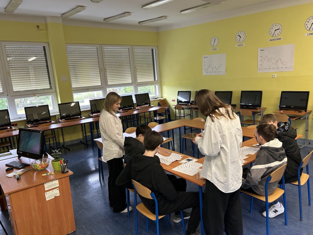 Uczniowie rozwiązujący zadania ekonomiczne podczas Dni Otwartych w ZSE.