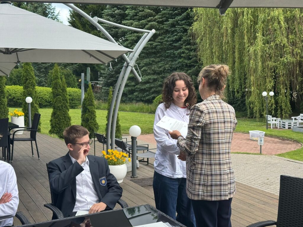 Uczennica odbierająca podziękowania i referencje za pracę w hotelu.