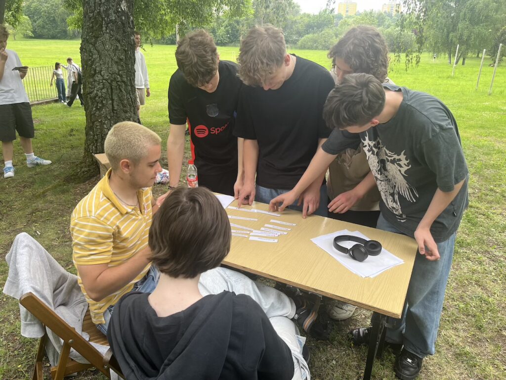 Uczniowie przy stanowisku rozwiązujący quizy.