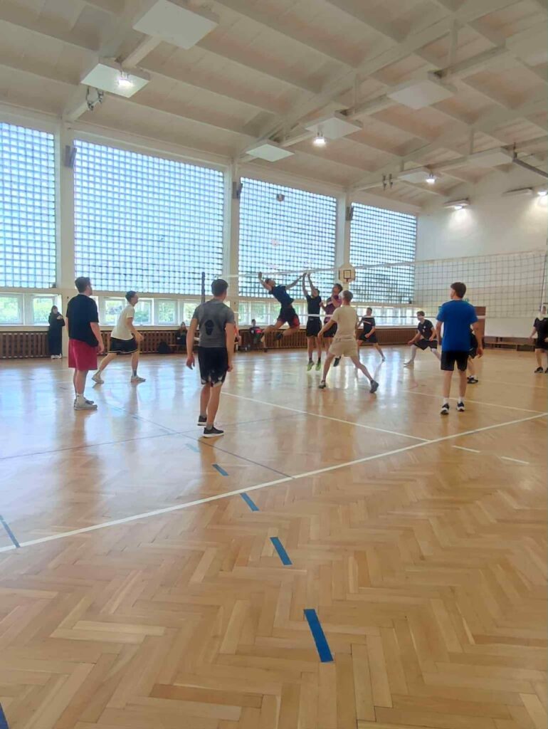 Uczniowie rozgrywający mecz piłki siatkowej.