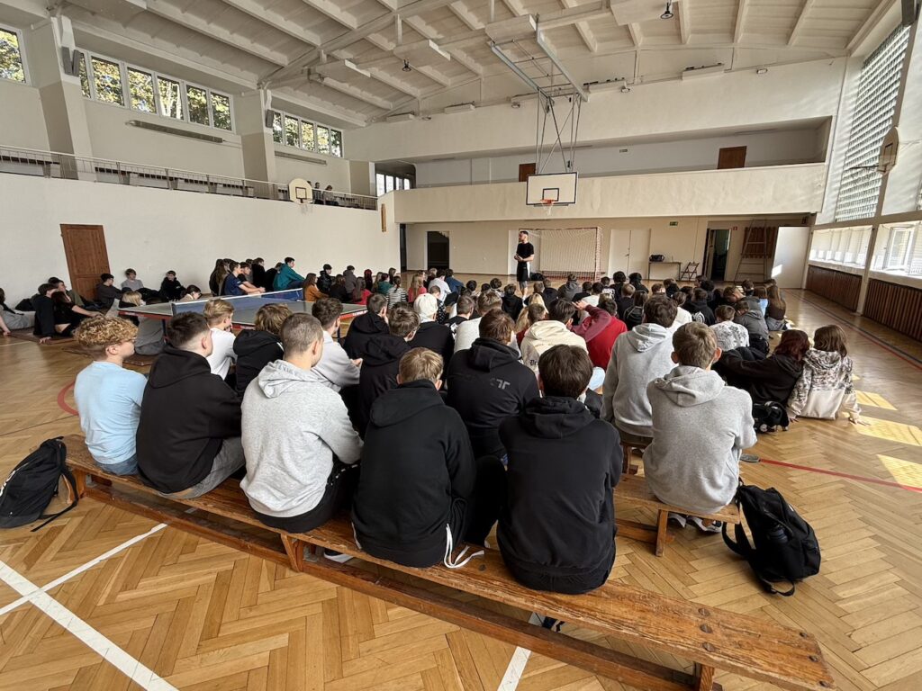Uczniowie podczas wykładu na sali gimnastycznej.