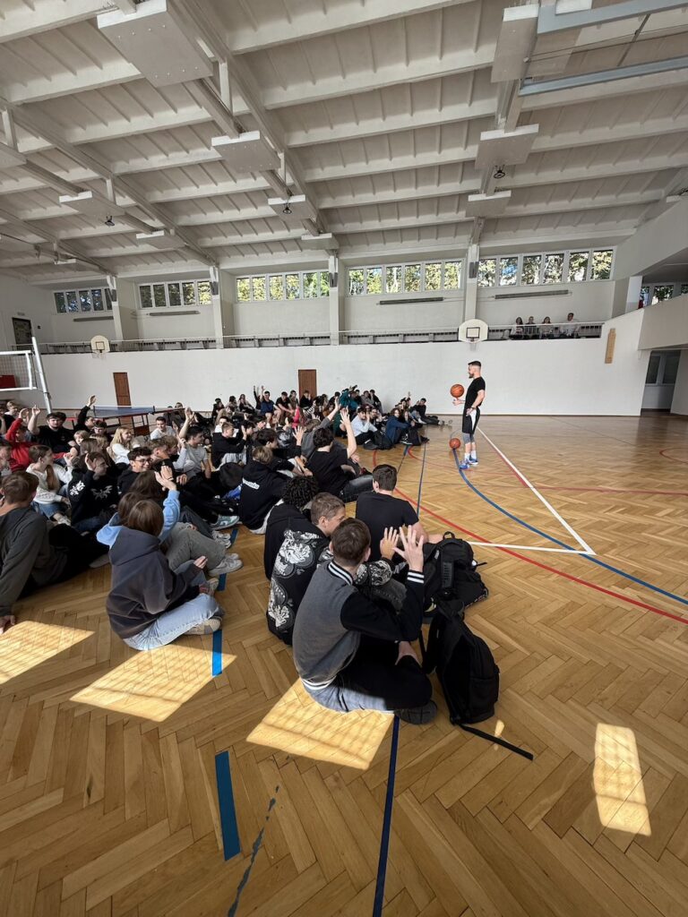 Uczniowie z prelegentem na sali gimnastycznej.