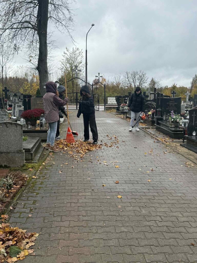 Uczniowie podczas sprzątania cmentarza