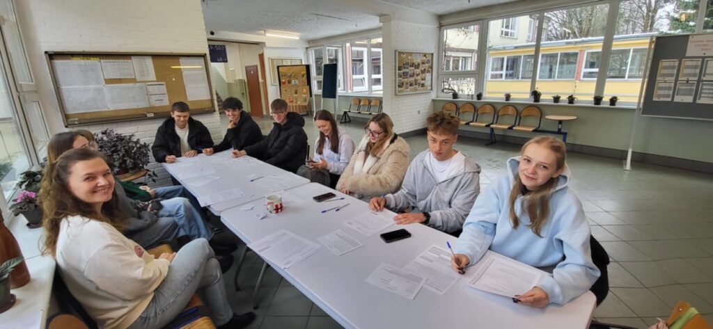 Uczniowie wypełniający dokumenty.