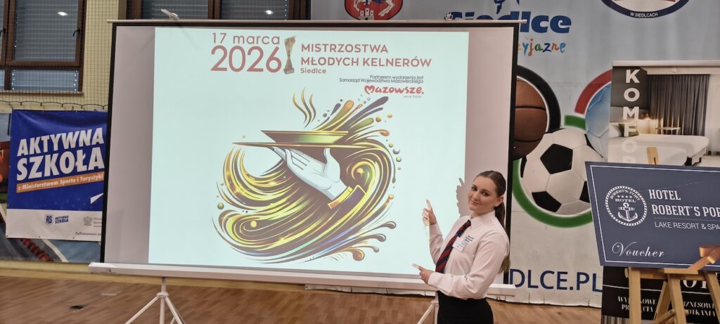 Uczennica pozująca przed plakatem.