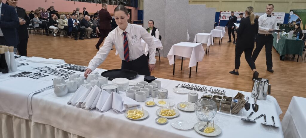 Uczennica podczas przygotowywania nakrycia stołu.