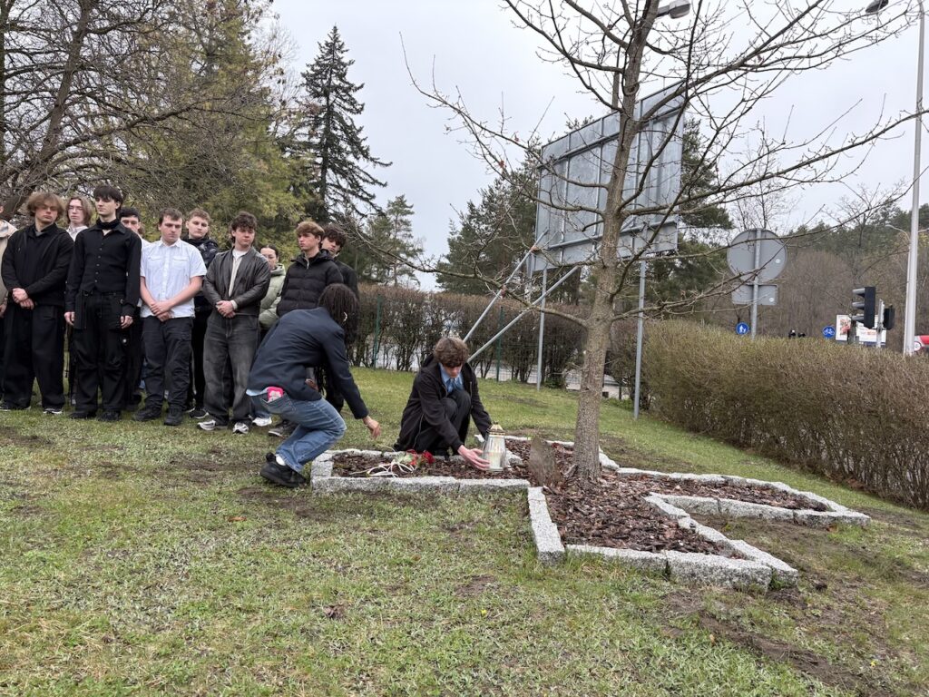 Uczniowie składający znicz pod Dębem Pamięci.
